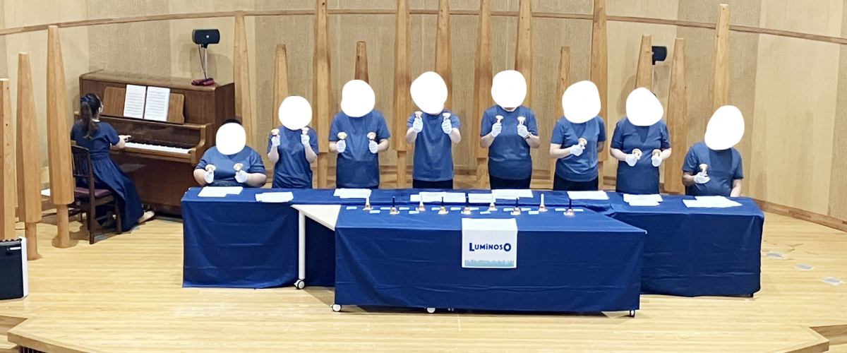 舞台でハンドベルを演奏している部員の写真