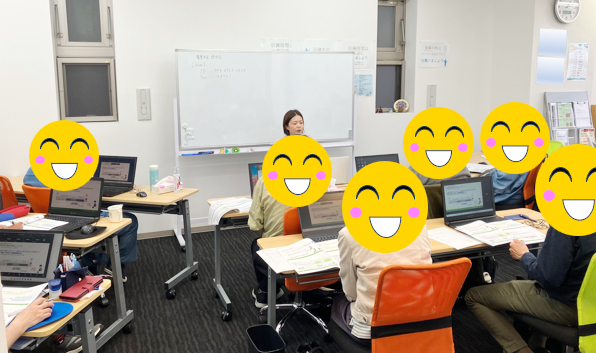 ホワイトボードを背に講義をする社労士と講義を受ける利用者さんの写真